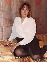 A mature blond takes of her clothes and pantyhose